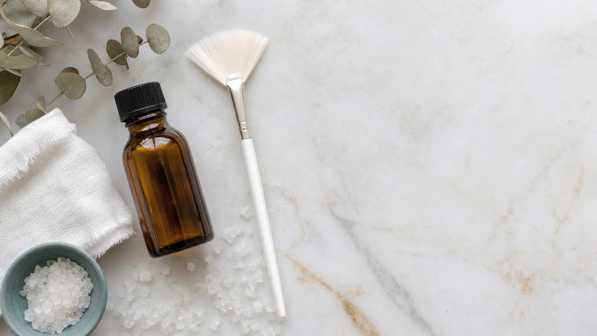 Exfoliating peel solution and applicator brush on a marble surface